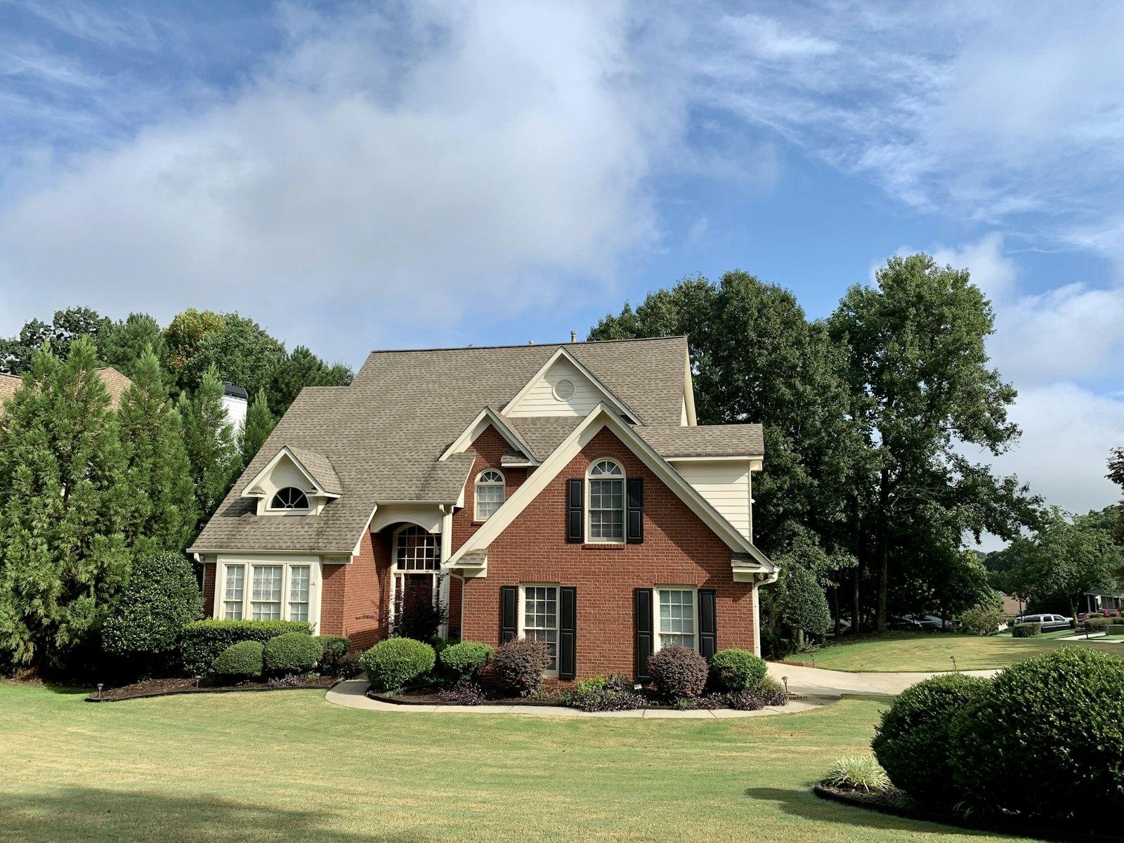 Brick two-story home with a new architectural shingle roof and landscaped beds