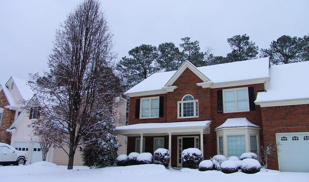 Brick colonial Michigan-style home blanketed in snow